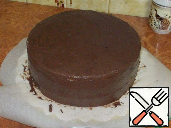 Cover the cake on top and sides with a thin layer of cream. The collected cake is sent to the refrigerator for a couple of hours. And add a spoonful of cocoa to the remaining cream and mix well.
