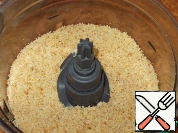 Scraps from the cakes are crushed in the bowl of a combine.
