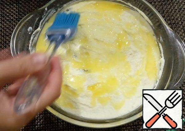 Grease the mold with butter and put the curd mass.
Melt the butter and spread half of the portion with a silicone brush over the surface of the casserole. The second half of the oil will come in handy a little later.
