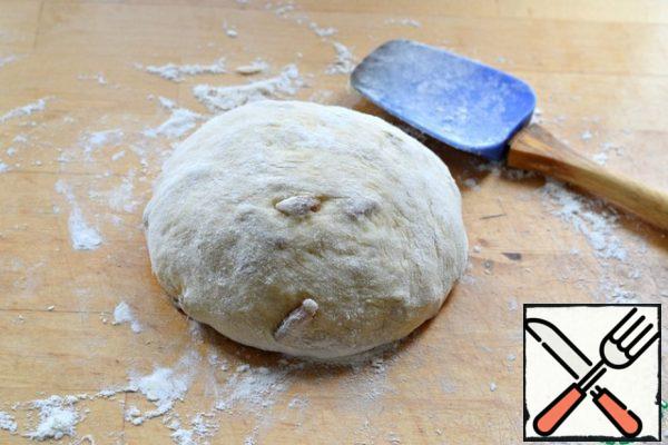 Sprinkle the work surface with flour. 20-25 grams will be enough, no more! Additional flour is absolutely not needed. This is important! Roll the dough in flour and roll it in flour from all sides with a spatula. The dough acquires a certain density and elasticity, and you can work with it, knead and shape the products with your hands.
