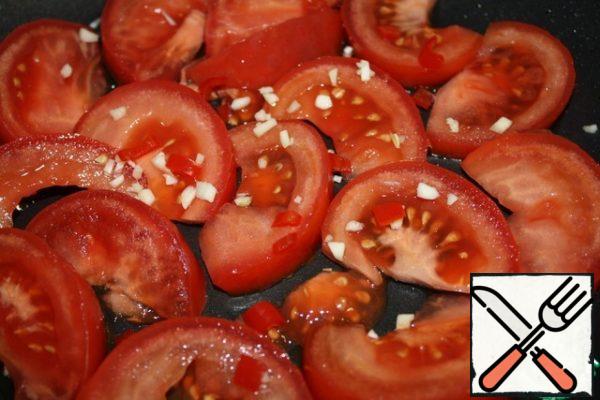 Grease the bottom of the pan with oil.
Put a piece of tomato, add a little salt and sprinkle with a pinch of garlic and pepper.
