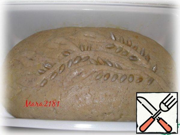 Since the dough does not contain gluten, the rise will be small. If desired, you can decorate the top of the bread using a little dough and sunflower seeds. Brush the surface with beaten egg.
