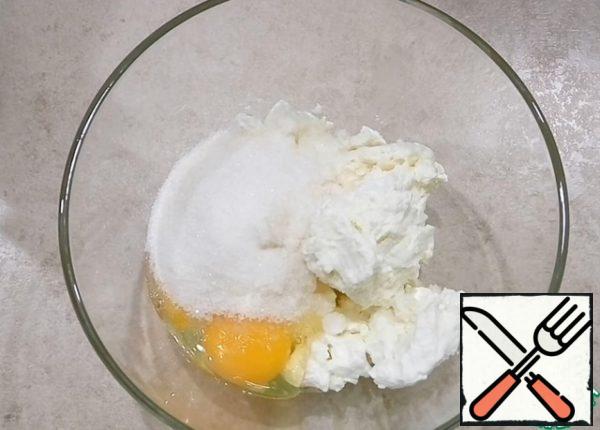 Add sugar, eggs, vanilla sugar, a pinch of salt and vegetable oil to the cottage cheese. If you like sweet pastries, you can add more sugar. Mix everything with a fork.
