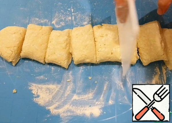 Dust the table with flour so that it is easy to work with the dough. Knead a little and divide into 8 equal parts.
