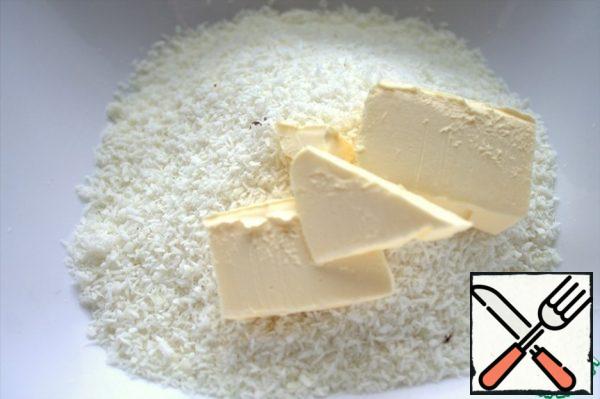 Add soft butter to the coconut chips.
