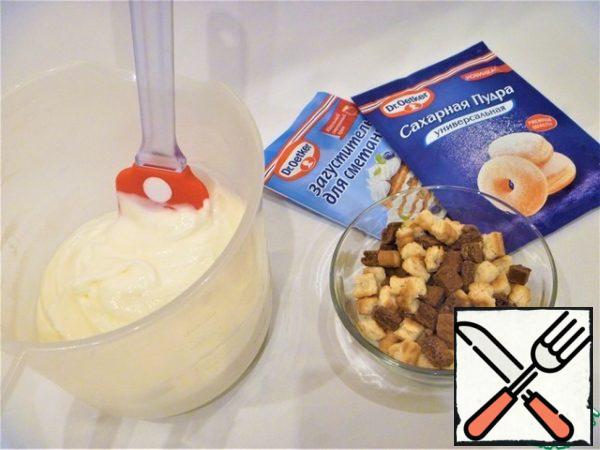 Break the cookies (or cut into cubes). Put the cooled sour cream in the whipping container, add powdered sugar, mix the contents with a mixer. Without stopping the mixer, add a thickener to the sour cream, beat the cream at high speed for 1-2 minutes. Put the cookies in the sour cream, mix.
