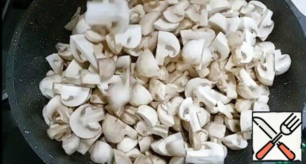 Heat a frying pan, add vegetable oil and put the mushrooms. Fry mushrooms over medium heat stirring occasionally.
Mushrooms fry until until all the liquid.