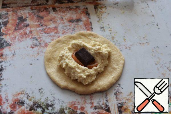 Shape the pies. Divide the dough into small pieces. Roll out the circles. Put a tablespoon of cheese in the middle, then fill, carefully seal and leave under a cloth.
