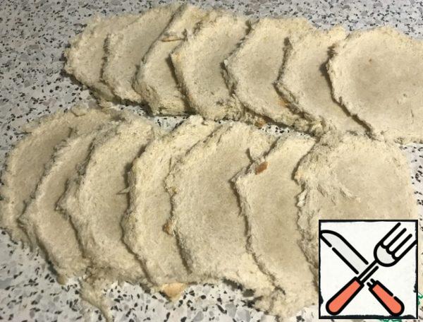 Cut the crust from the loaf slices. Roll out with a rolling pin.
