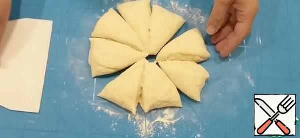Then brush the dust off the table to make it easier to work with the dough. Divide it into 8 equal parts.
