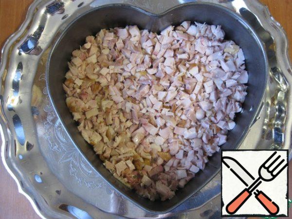 Chicken meat is separated from the bones, remove the skin and cut into small cubes, put a second layer, slightly compacting..
Here, in principle, it is possible to take or smoked chicken, but in this case it is better to bake or fry in a pan with spices, just boiled, this salad will be boring).