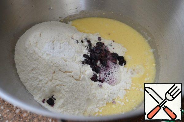 Add the sifted flour, berries and soda to the creamy egg mixture.
