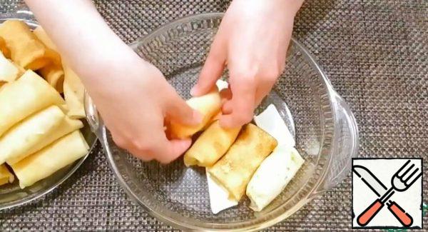 Put small pieces of butter on the bottom of the baking dish and put the pancakes with cottage cheese in one layer.
