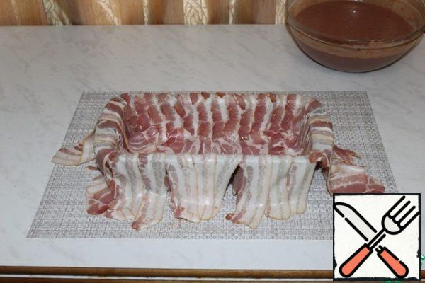 Cover the rectangular
baking dish with strips of bacon
overlapping so that the edges hang down.
