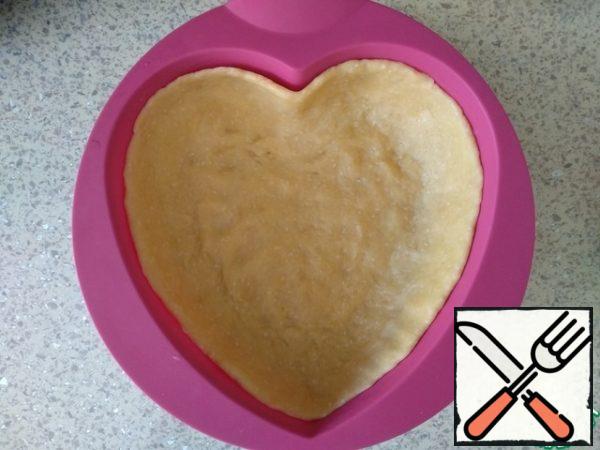 Distribute the dough in the form, forming the sides. My form is silicone (about 16-18 cm), so there is no need to lubricate. Put it in the refrigerator while we prepare the filling.
