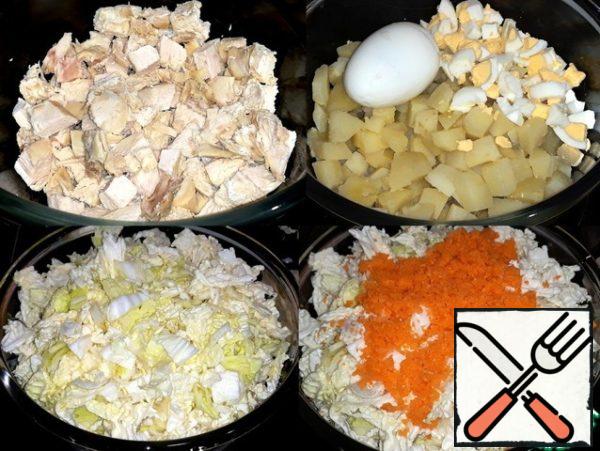 Boiled chicken and potatoes cut into cubes.
Crumbled the eggs. Chopped cabbage. Finely
sliced a peeled Apple. For juicy carrots
shredded in the shredder.