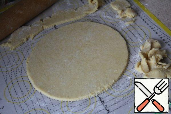Roll out one half and cut out a circle (I have a shape with a diameter of 21 cm). From scraps to make strips for the top of the cake.
