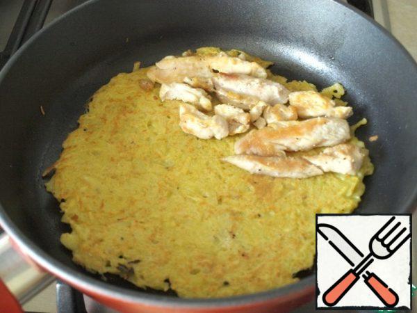 Put a third of the potato mass in a frying pan, well heated with oil, evenly distributed over the bottom. When the bottom is fried, turn it over. Put the chicken pieces on half of the pancake, also the third part.
