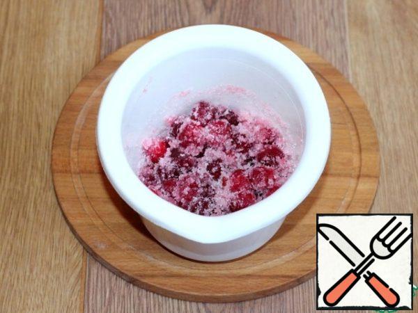 The frozen cranberries are washed with running water. Then spread the cranberries in a bowl of blender, add sugar and grind until smooth.