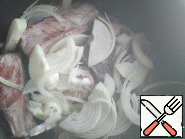 Cut the onion into half rings and put it to the meat, fry for 5 minutes over medium heat.
