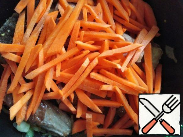 Cut the carrots into strips and put them in a cauldron with onions and meat, fry until the carrots are soft.
