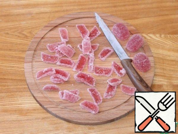 Prepare the filling. Melt the butter (50 g) in the microwave.
Slices of marmalade cut into plates.
Fry the nuts in a dry frying pan and chop.
Cut each sausage into 2 parts.