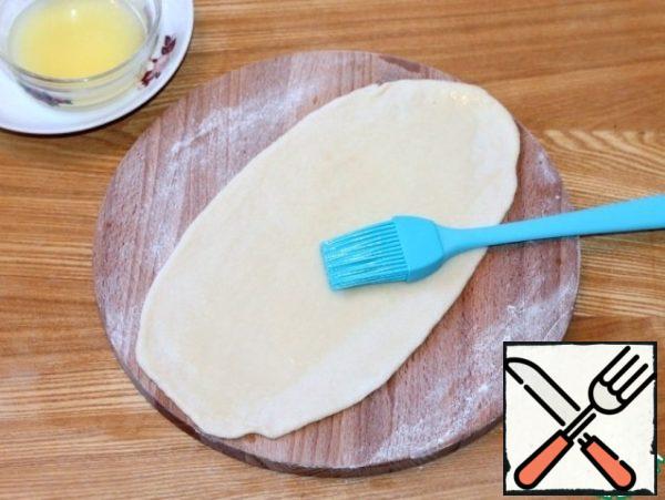 Form rolls of 6 pieces of dough. Roll out each part of the dough alternately into a long tortilla (~ 30 * 7 cm), smear with melted butter. If you are a lover of sweeteners, you can sprinkle a little sugar.
