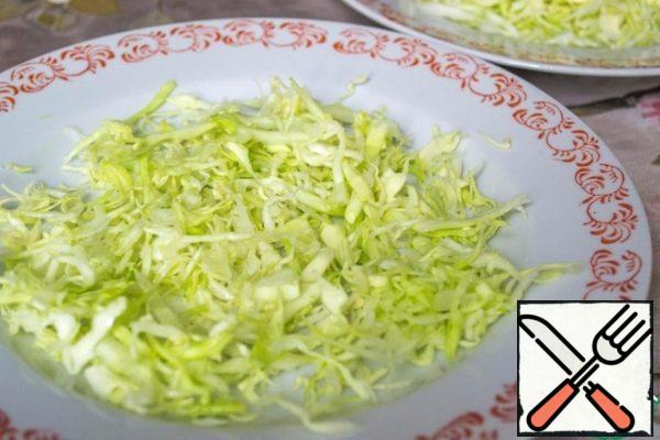 While we're sorting out the rest of the ingredients, put the breast to cook. To make it more fragrant, I add half an onion to it, with which they are cooked until the breast is ready.
Since there was no Peking cabbage in the store this time, I used young white cabbage, by the way, it also turned out very tasty. So, chop the cabbage finely, if you take the Peking cabbage, you can chop it larger. Brush with a thin mesh of mayonnaise.
