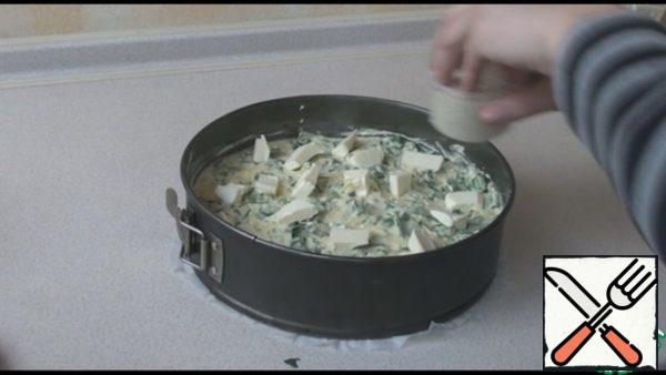 Spinach, if it is fresh, wash, dry and chop. If frozen, defrost, drain excess liquid. Add to the dough and mix well. Form with a diameter of 24 cm, cover the bottom with parchment paper. Brush with butter and spread the dough. Cut the butter into cubes and spread over the dough. If you have too many calories, you don't have to do it, it will also be delicious.
