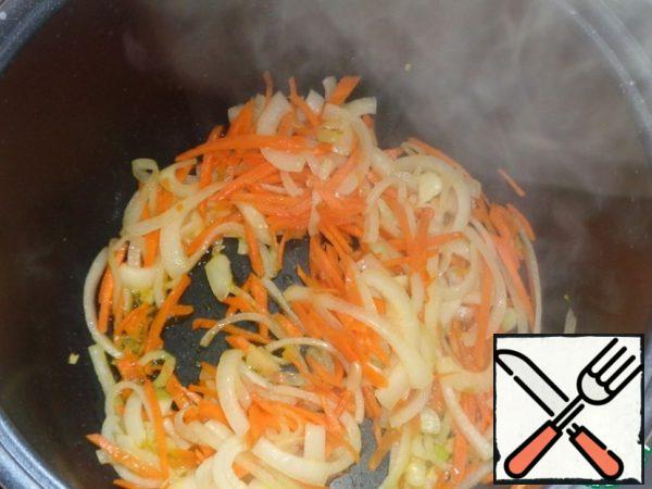 We put the slow cooker on the "Frying" mode, the time is 35-40 minutes, pour a little vegetable oil on the bottom of the bowl and fry onions and carrots until half-cooked with the lid open. Then season with salt and pepper to taste. You can take any, I have paprika, pepper and coriander. We also send finely chopped garlic and a small piece of butter there. Stir and fry a little more
