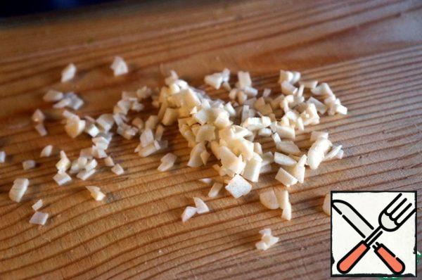 Peel the garlic cloves, chop them finely, and send them to a bowl.
