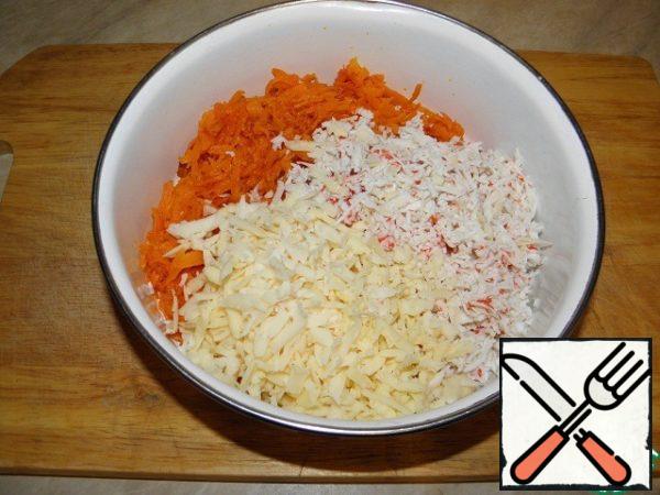 Grate crab sticks and cheese on a coarse grater and add to the roasted carrots.
