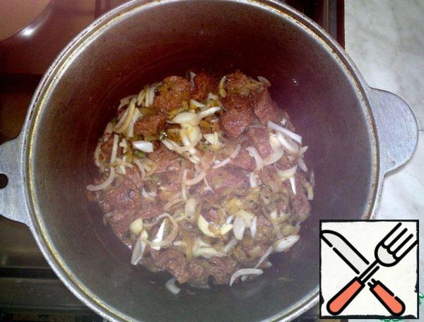 When the meat is browned, I spread the onions and pickles. Keep frying. At this stage, add sugar. This will help the onion extract juice and, at the same time, act as a flavor enhancer.
