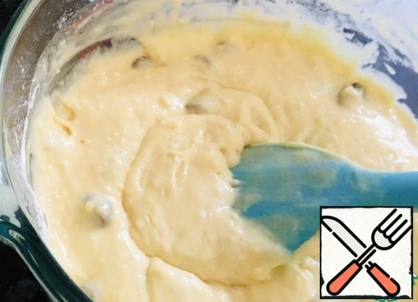 Add the sifted flour, mix with a silicone spatula so that the dough turns out without lumps, add raisins.
