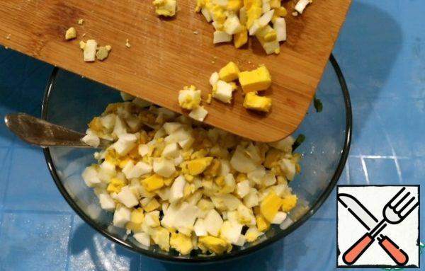 Add the chopped eggs to the onion and mix.
