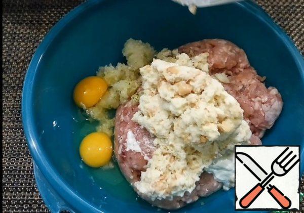 Add salt, pepper, eggs, soaked buns and spoon a slide of sour cream. Mix well and leave for 15 minutes.
