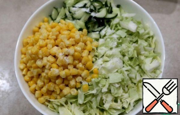 Mix cucumbers, corn and cabbage in a bowl, adding salt, freshly squeezed lemon juice and vegetable oil.
