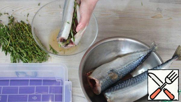 The fish is abundantly watered with marinade, lubricate inside, the remaining branches of thyme and rosemary put inside the fish, you can put on top of the fish, put in a container and leave to marinate for 30-40 minutes.For a long time it is better not to leave the fish, as it does not need a long marinating.