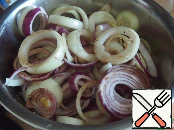 First peel the onion and cut it into rings, you can use any onion, I have a white and red onion in half. Put the onion in a bowl and add 2 tablespoons of sunflower oil. Sprinkle with ginger, cinnamon, sugar and pepper, grated on a fine grater. Stir the onion and leave to marinate for 2 hours.
