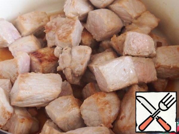 Cut the meat into pieces. In a saucepan with a thick bottom, fry the pieces of meat in the remaining oil.
