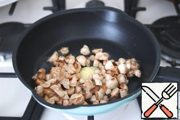Pre-cut the fish into fillets, cut into pieces. Add 2 tablespoons of ghee to the pan, add chopped mushrooms (3 handfuls).