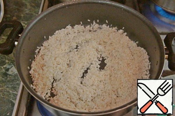 Wash rice until clear water, put in a pan, add oil and fry until light brown colour on medium heat.