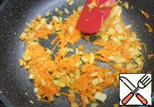 On a fine grater grate the carrots and tomato. I have frozen tomatoes this time. Onions cut into cubes.
Put the pan on the fire, add vegetable oil and fry onions and carrots until soft.