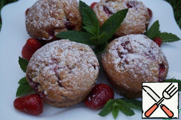 Remove the muffins from the molds, decorate with strawberries and mint leaves. Sprinkle with powdered sugar and serve!
