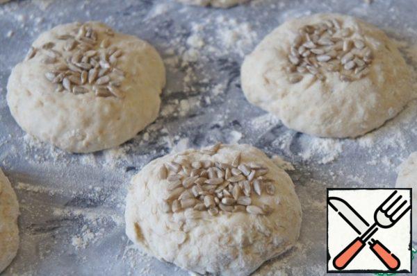Lubricate the mold with oil and cover with baking paper or a silicone mat. Separate the portions of dough with a spoon and roll them into balls with floured hands.
