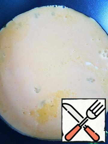 Melt some butter in a pan. Pour the egg mixture. When the omelet "grabs", reduce the heat to medium.