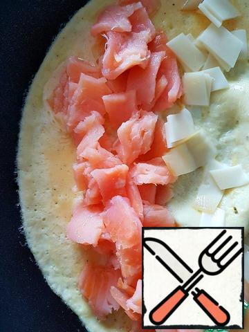 At this time, one edge of the omelet lay the sliced fish and most of the cheese. Cheese can be grated.