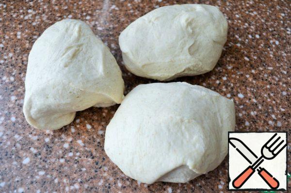 After an hour, the dough is ready, soft, elastic.
Divide it into 3 equal parts, in my case 307 g..
Roll into balls and put under the film.
