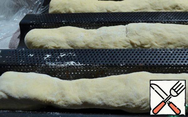 Roll out the roll in length to make a baguette.
Put it in a baguette, cover with a film and leave for 10 minutes.
