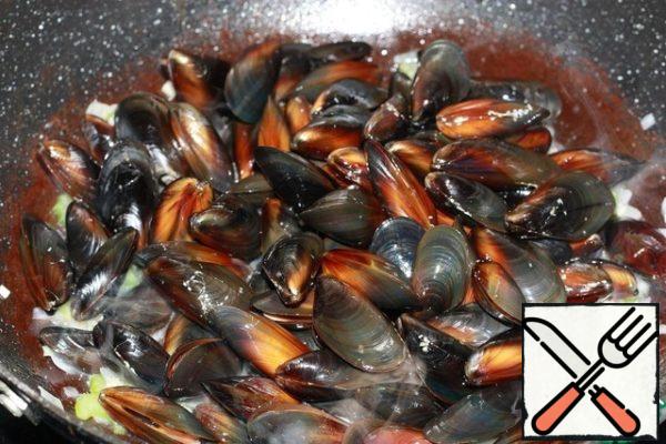 Put the mussels, close the lid. Simmer the mussels for 2-3 minutes, shaking the pan regularly so that the mussels are covered with wine evenly.